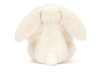 A Jellycat, Blossom Bunny Berry Little with bashful fur and long ears sits elegantly on a pristine white surface.
