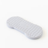Bumkins Silicone Teether: Nintendo SNES™ Controller lays face down on a white background, showcasing the raised dots on the back.