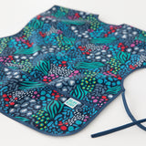 Close-up of Bumkins Short-Sleeved Smock: Animal Prints on a white background, with focus on the bottom pocket.
