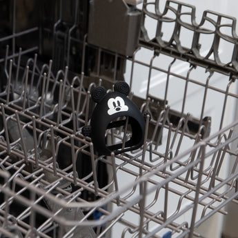Bumkins Silicone Un-Droppable Mitt Teether: Mickey Mouse sits in the top rack of an open dishwasher.
