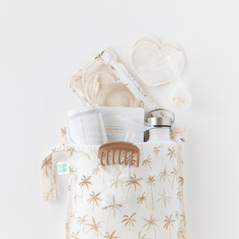 Two bags from Bumkins The Playdate Planner Deluxe 5-Piece Set: Palm Daze hold breast pump parts, a bottle, & more on a white background.