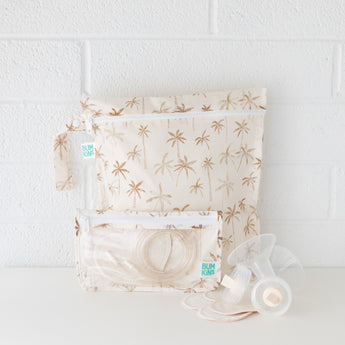 Two bags from Bumkins The Playdate Planner Deluxe 5-Piece Set: Palm Daze hold breast pump parts on a white counter against a white wall.