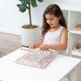 A young girl unzips the Bumkins Wet Bag + Clear Travel Bag 3 Pack Set in Sand Check for organized travel.
