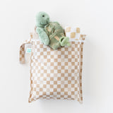 Bumkins Wet Bag + Wet/Dry Bag Set in Sand Check holds a plush turtle, pacifier, and essentials; all on a white background.