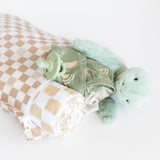 Roamio by Bumkins Wet Bag: Sand Check holds a rolled blanket, green pacifier, clothes, and plush turtle on a white background.
