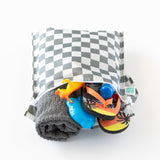 Bumkins Wet Bag: Charcoal Check is packed with a towel, toy dinosaur, flip-flops, and a blue water bottle peeking out on a white background.