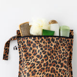 Roamio by Bumkins Wet Bag: Leopard filled with toiletries lays on a white background.