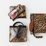 Roamio by Bumkins The Commuter Essential 4-Piece Set: Leopard holds shoes, makeup, and headphones on a white background.