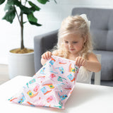 A young girl opens the Bumkins Wet Bag + Travel Bag + Tote Set: Boots—perfect for organizing essentials on the go.