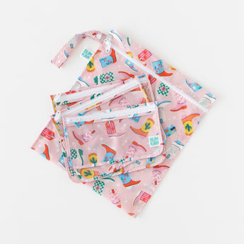 Four bags from Bumkins The Playdate Planner Deluxe 5-Piece Set: Boots lay stacked on a white background.