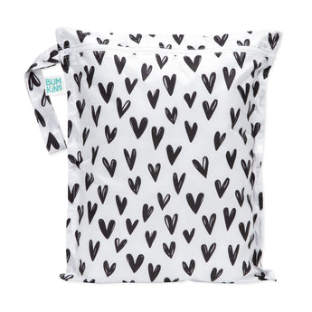 Bumkins Wet Bag: Hearts features a black heart pattern on white waterproof fabric, a zipper closure, and side handle.