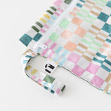 Close-up of Roamio by Bumkins Wet Bag: Motley Check on a white background, with focus on the zipper and side handle.