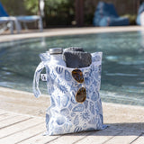 Roamio by Bumkins Wet Bag: Shells holds sunglasses, a towel, and water bottle poolside.
