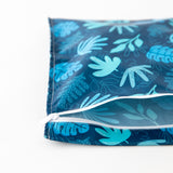 Bumkins Wet Bag: Blue Tropic lays partially open on a white background, revealing the interior.
