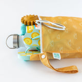 Bumkins Wet Bag: Sunshine, shown from the side, holds a water bottle, teal towel, and sun-printed sandals on a white background.