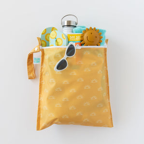 Bumkins Wet Bag: Sunshine holds a bottle, SPF 50 sunscreen, sunglasses, shoes, toy, and towel on a white background.