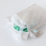 Breastfeeding essentials peek out of an open Bumkins Wet Bag: Wander laying on a white background.