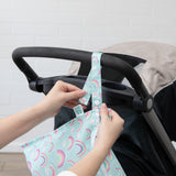 Hands attach the Bumkins Wet Bag + Wet/Dry Bag Set: Rainbow to a stroller—eco-friendly, on-the-go storage made easy.