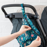 A person zips a Bumkins Wet Bag + Clear Travel Bag 3 Pack Set: Jungle onto a stroller—perfect for travel essentials.