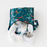 Bumkins Wet Bag: Jungle holds breast pump parts, cloth, and a water bottle on a white background.