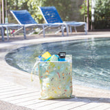 The Bumkins Wet Bag + Wet/Dry Bag Set: Camp Gear sits poolside, packed with essentials, lounge chairs in the background.
