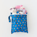 Bumkins Wet Bag: Mickey & Friends Forever lays on a white background holding a unicorn toy, pink sunglasses, and a book.