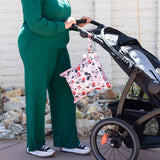 Bumkins Wet Bag: Minnie Mouse Classic hanging from a stroller