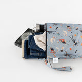 Bumkins Wet Bag: No Tricks, Just Treats holds jeans, a white shirt, thermos, and book on a white background.