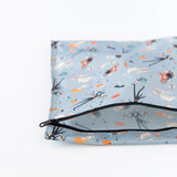 Bumkins Wet Bag: No Tricks, Just Treats lays unzipped on a white background, revealing its interior.