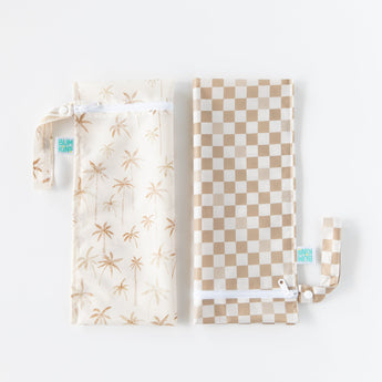 Bumkins Wet Bag 2 Pack: Palm Check—one with a palm design and another in beige checks lay folded next to each other on a white background.