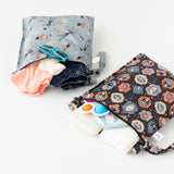 The Bumkins Wet Bag 2 Pack: Disney Everyday Is Halloween holds clothes, wipes, a toy & more on a white surface.