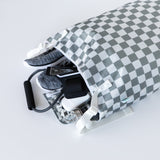 Bumkins Extra Large Wet Bag: Charcoal Check opens to reveal sneakers, phone, and gym gear spilling onto a white background.