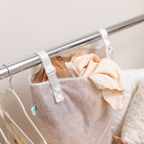 Bumkins Extra Large Wet Bag: Wander, hanging from a metal rail, is filled with folded clothes and has adjustable snap handles.