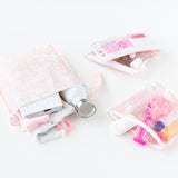 Bumkins The Chaos Coordinator Essential 4-Piece Set: Lace holds toiletries, a water bottle, & clothes on a white background.