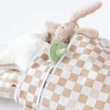 Close-up of a plush bunny and green pacifier in a chic Bumkins Wet/Dry Bag: Sand Check, crafted from waterproof fabric, on a white background.