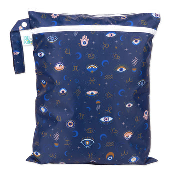 Bumkins Wet/Dry Bag: Evil Eye features celestial prints with eyes, stars, moons, and zodiac signs on dark blue waterproof fabric.