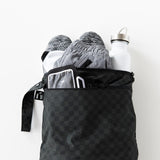 Roamio by Bumkins Wet/Dry Bag: Rich Black holds shoes, clothes, and a water bottle on a white background.