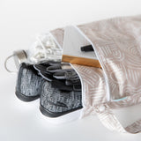 Open Bumkins Wet Bag + Wet/Dry Bag Set: Wander with sneakers, gloves, notebook, earphones & water bottle on white surface.
