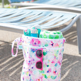 The Bumkins Wet Bag + Wet/Dry Bag Set: Watercolor sits by blue lounge chairs near the pool.