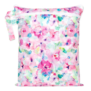 Bumkins Wet/Dry Bag: Watercolor features pink, blue, and green florals on waterproof fabric with a zipper and handle.