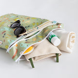 Bumkins Wet Bag + Wet/Dry Bag Set: Camp Gear holds sunglasses, towel, cream, and brush on a white background.