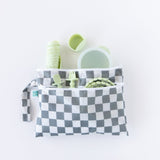 Bumkins Wet/Dry Clutch: Charcoal Check holds a cup, spoon, fork, and bottle in green on a white background.