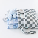 Bumkins Wet/Dry Clutch: Charcoal Check is unzipped to reveal folded clothes and a blue plush bunny on a white backdrop.