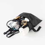 Bumkins Wet/Dry Clutch: Rich Black lays open on a white background, with a towel, bottle, and gym gear.