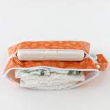 Bumkins Wet/Dry Clutch: Grounded lays open on a white background, holding wipes, diapers, and clothes.