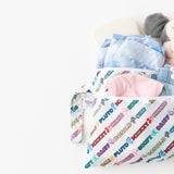 Bumkins Wet/Dry Clutch: Mickey & Friends Varsity, overflowing with clothes and a plush toy, is shown on a white background.