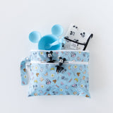 Bumkins Wet/Dry Clutch: Mickey + Minnie Sunny Side Up holds a patterned bib, a blue bowl and spoon, and Mickey utensils on a white background.
