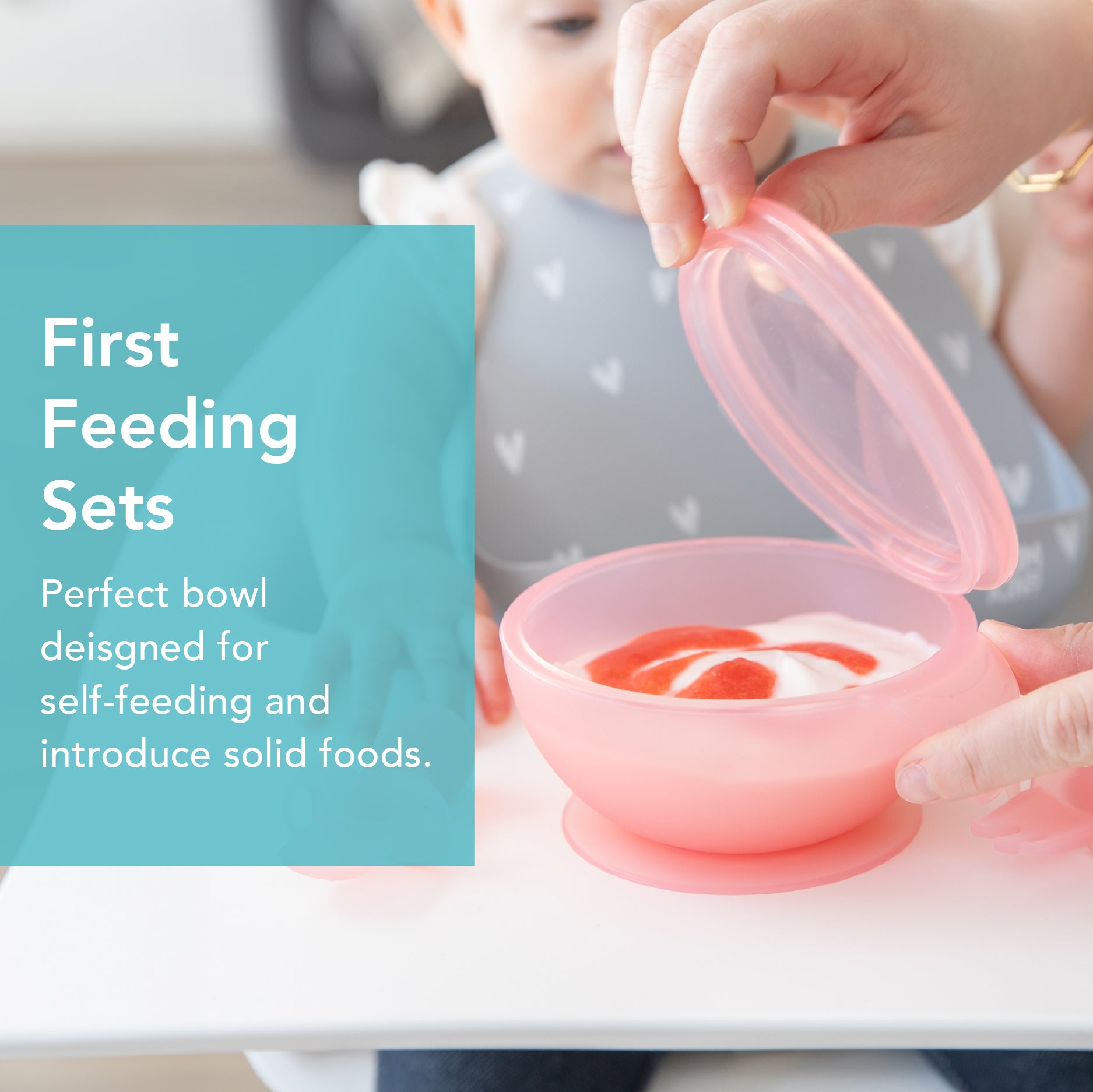 A baby in a bib reaches for a pink bowl with puréed food on a highchair tray. An adult is lifting the lid. Text reads, First Feeding Sets: Perfect bowl designed for self-feeding and introduce solid foods.