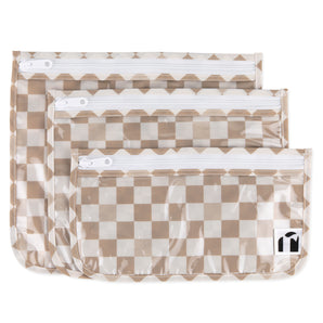 Roamio by Bumkins Clear Travel Bag 3 Pack: Sand Check includes 3 TSA-compliant pouches made of tan checkered waterproof fabric with zippers.