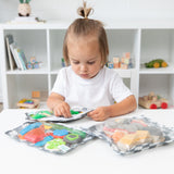 A child plays with sensory toys stored in Bumkins Charcoal Check Wet Bag + Wet/Dry Clutch + Clear Travel Bag 3 Pack Set.